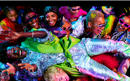 Kleurrijk scherm op een MacBook Pro van iemand die op een feestje crowdsurft, ter illustratie van het levendige Liquid Retina XDR-display